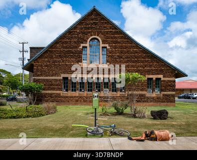 Eine nicht identifizierte Person liegt auf dem Bürgersteig in der Nähe eines Fahrrads vor dem Kaua’i Museum in der Innenstadt von Lihue in der Rice Street. Stockfoto