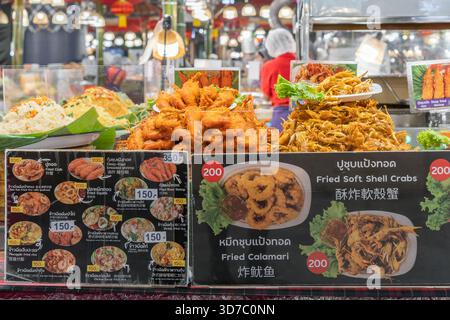 Bangkok, Thailand - Januar 21,2025 : lebhafter Street Food-Stand mit gebratenen Softshell-Krabben, Calamari und verschiedenen thailändischen Snacks Stockfoto