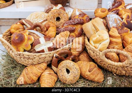 Körbe überflutet mit verschiedenen Brotsorten in verschiedenen Formen in lokaler Bäckerei-Umgebung. Stockfoto
