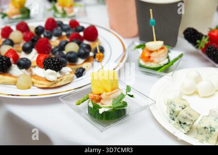 Ein köstliches Aufstrich mit Gourmet-Vorspeisen mit Garnelen und Ananas, frischem Obst auf Pfannkuchen und verschiedenen Käsesorten. Perfekt für einen sophi Stockfoto