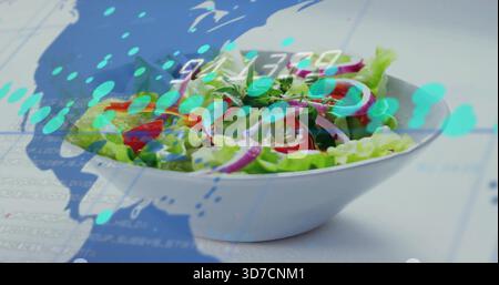 Weiße Schüssel mit Salat auf Studiotisch mit blauer Kartenüberlagerung und numerischer Anzeige Stockfoto