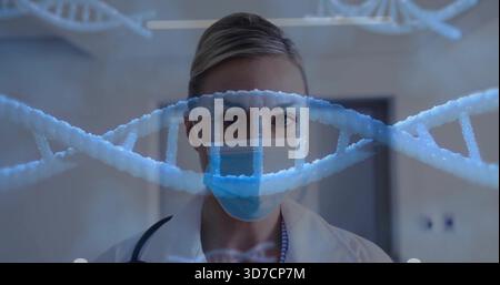Stehende Ärztin in der Klinik mit Kamera, Maske, weißem Mantel, Stethoskop-DNA-Helix Stockfoto
