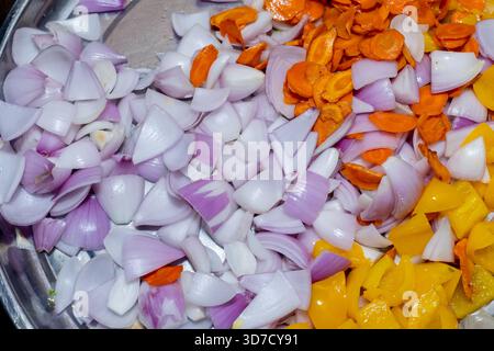 Frisch gehacktes Gemüse, Zwiebeln, Karotten, fertig zum Kochen, eine bunte kulinarische Zubereitung Stockfoto
