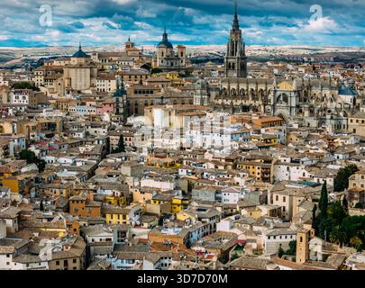 Aus der Vogelperspektive auf alte Gebäude und die Kathedrale von Toledo unter einem bewölkten Himmel, Toledo, Kastilien-La Mancha, Spanien. Stockfoto