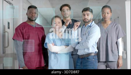 Posieren von fünf Pflegekräften mit Peelings und Hemd mit Stethoskop in der Krankenhausstation mit HUD Stockfoto