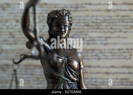 Die Statue der Gerechtigkeit Themis, die Göttin der Gerechtigkeit mit den Augen gegen die US-Verfassung Seite. Urteil und Strafe in den Vereinigten Staaten Stockfoto