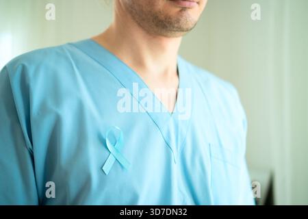 Nahaufnahme eines männlichen Arztes mit medizinischer Uniform mit blauem Satinband. November Prostatakrebs Awareness Monatskonzept, Prävention, Früherkennung und onkologische Behandlung. Stockfoto