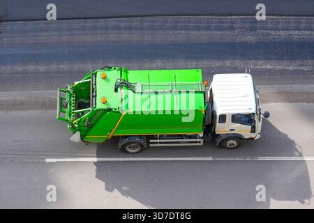 Recycling-Truck fährt auf der Straße in der Stadt, aus der Luft. Stockfoto