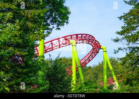 Achterbahn nach oben und nach unten und eine vorbeifahrende Schleife fettt, Spirale neigt dazu, nach unten zu gehen Stockfoto