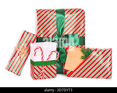 Vier Weihnachtsgeschenke in rot und grün gestreiftes Papier mit grünem Band, Zuckerstangen und einem leeren braunen Geschenkanhänger. Hochwertige Fotos Stockfoto