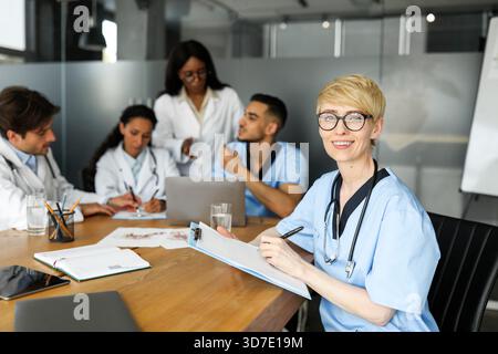 Porträt einer jungen blonden Ärztin, die mit Kollegen Brainstorming gemacht hat Stockfoto