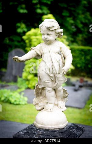 Steinengel-Kind-Statue auf dem Grabdenkmal auf dem Friedhof Stockfoto