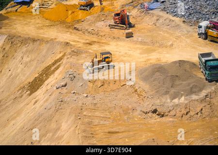 Luftaufnahme direkt über einem Industrie-Dumper oder Erdbewegungsfahrzeug mit matschigem Boden und Reifenspuren in der Bauindustrie auf einem Brownfi Stockfoto