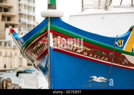 Marsaxlokk, Malta - 13. April 2025: Traditionelle, farbenfrohe maltesische Fischerboote namens Luzzu mit hellblauen, gelben und roten Details, die im malerischen Hafen von Marsaxlokk ankern Stockfoto