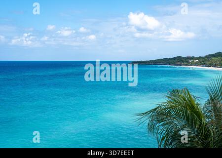 Klares türkisfarbenes Wasser trifft auf weißen Sand und üppiges Grün am Bira Beach in Sulawesi, Indonesien, unter einem hellen tropischen Himmel Stockfoto