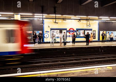LONDON - 29. OKTOBER 2025: U-Bahn-Station Aldgate East – Bahnsteig der District & Hammersmith & City Line in Richtung Osten mit abfahrendem Zug Stockfoto