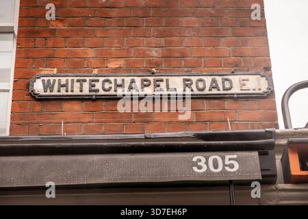 LONDON – 29. OKTOBER 2025: Whitechapel Road E1 – Vintage Emaille Straßenschild an roter Backsteinmauer, East London Stockfoto