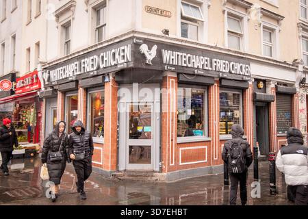 LONDON – 29. OKTOBER 2025: Whitechapel Fried Chicken, Court Street – Halal Take away und multikulturelles Straßenleben an einem regnerischen East London Day Stockfoto
