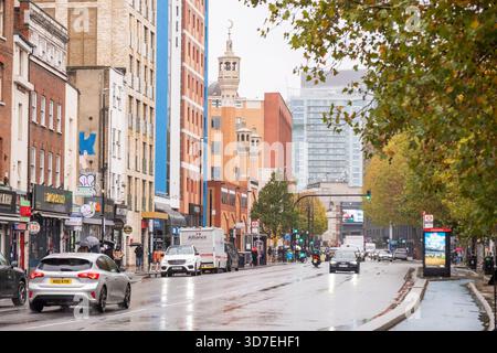 LONDON – 29. OKTOBER 2025: Whitechapel Road – Minarett der East London Mosque, das sich am regnerischen Herbsttag über der multikulturellen Straße erhebt Stockfoto