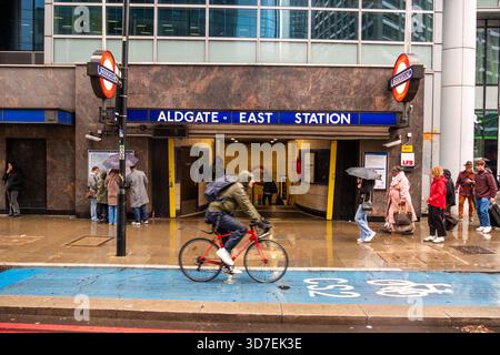 LONDON – 29. OKTOBER 2025: Aldgate East Station E1 – Pendler und Radfahrer an regnerischen Tagen mit klassischen Londoner U-Bahn-Roundels Stockfoto