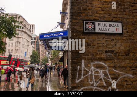 LONDON - 29. OKTOBER 2025: Schild Aldgate - Blue Boar Alley E1 neben dem Eingang der Aldgate Station an regnerischen Tagen Stockfoto