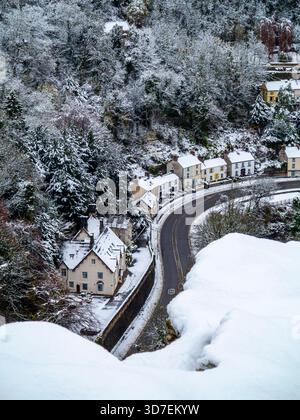 Schneebedeckte Szene mit der A6 Road und Artists Corner mit Bäumen und Häusern im Matlock Bath im Derbyshire Peak District England, Großbritannien. Stockfoto