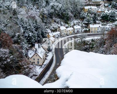 Schneebedeckte Szene mit der A6 Road und Artists Corner mit Bäumen und Häusern im Matlock Bath im Derbyshire Peak District England, Großbritannien. Stockfoto
