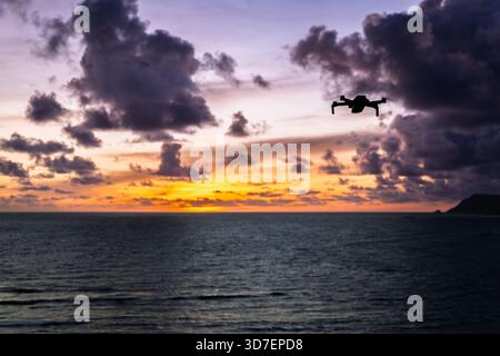 Lombok Indonesia – Drohne fliegt über Bukit Merese und fängt Klippen, Meerblick und einen lebhaften Sonnenuntergang an der zerklüfteten Küste ein. Stockfoto