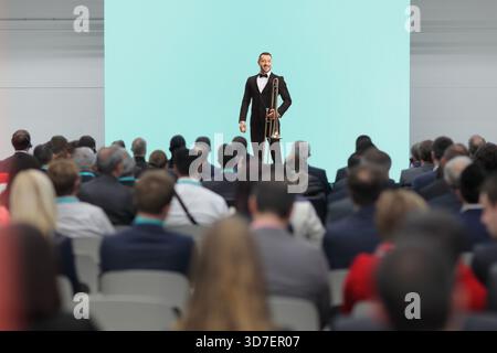 Männlicher Musiker mit Posaune, der vor Publikum auf der Bühne steht Stockfoto