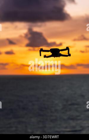 Lombok Indonesia – Drohne fliegt über Bukit Merese und fängt Klippen, Meerblick und einen lebhaften Sonnenuntergang an der zerklüfteten Küste ein. Stockfoto