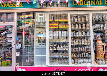 Souvenirladen in Köln, Deutschland, mit Reihen traditioneller deutscher Biersorten in einem hellen Straßenfenster. Stockfoto