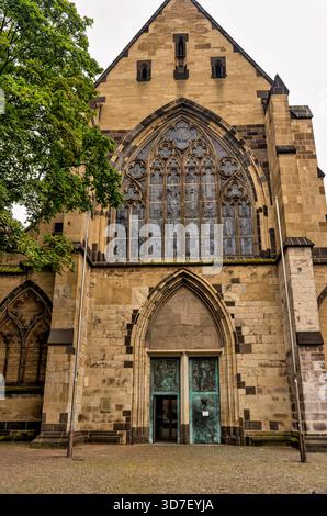 Fassade von St. Aposteln in Köln, Deutschland, mit Mauerwerk, gotischen Fenstern und dem Haupteingang. Stockfoto