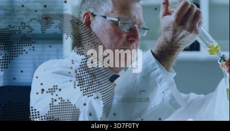 Leitender Forscher pipettiert gelb-grüne Flüssigkeit im Labor mit Labormantel und gepunktetem Überzug in einen Becher Stockfoto