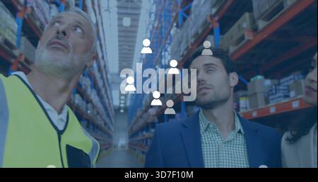 Inspektionsteam trägt Sicherheitsweste und Blazer-Scanning-Racks im Lagergang, Überlagerungssymbole Stockfoto
