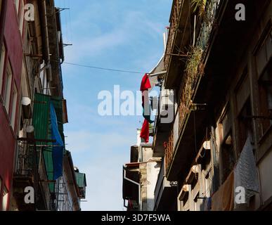 Balkone mit portugiesischer Nationalflagge in einer engen Straße, die das lebendige Wesen des Stadtlebens und das reiche kulturelle Erbe in der städtischen Umgebung hervorheben Stockfoto