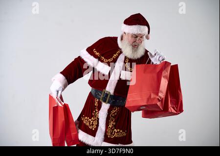 Ein Porträt des Weihnachtsmanns mit roten Paketen auf weißem Hintergrund Stockfoto