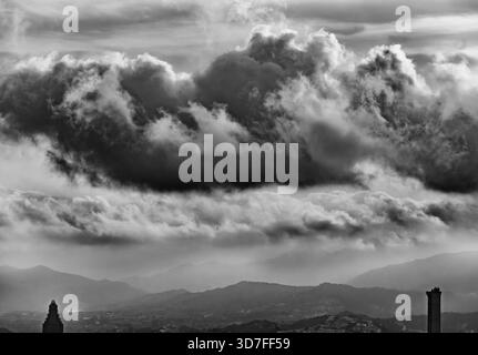 Ein kontrastreiches Schwarzweißbild, das eine spektakuläre, zweischichtige Sturmwolke zeigt, die dramatisch über der städtischen Landschaft hängt Stockfoto