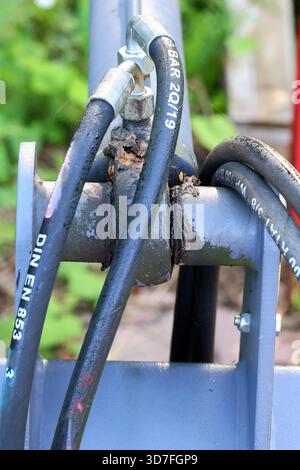 Nahaufnahme von Hydraulikschläuchen und -Anschlüssen bei Landmaschinen Stockfoto