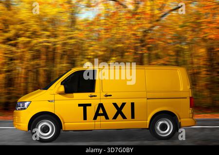 Gelbes Taxi mit Top-Schild und Logo, das auf der Straße fährt. Bewegungsunschärfeeffekt Stockfoto