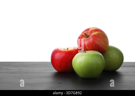 Rote und grüne reife Äpfel auf Holztisch vor weißem Hintergrund Stockfoto