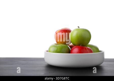 Rote und grüne reife Äpfel in der Schüssel auf Holztisch vor weißem Hintergrund Stockfoto