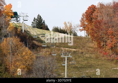 Bewölkter Herbsttag mit Blick auf eine leere Skipiste mit Sessellift, lebhafte Herbstfarben und keine Menschen, Kanada Stockfoto