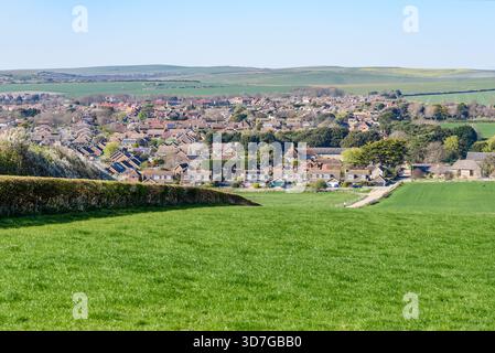 Backsteinhäuser in einem Wohnviertel am Stadtrand an einem klaren Frühlingstag. Rollende landwirtschaftliche Felder sind im Hintergrund sichtbar. Stockfoto
