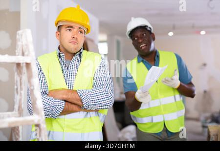 Porträt eines verwirrten Baumeisters und wütenden Baumeisters auf der Baustelle Stockfoto