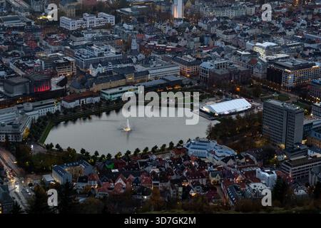 Abendlicher Blick auf Lille Lungegårdsvannet, während die Lichter der Stadt und die Fenster die Szene am See beleuchten. Stockfoto