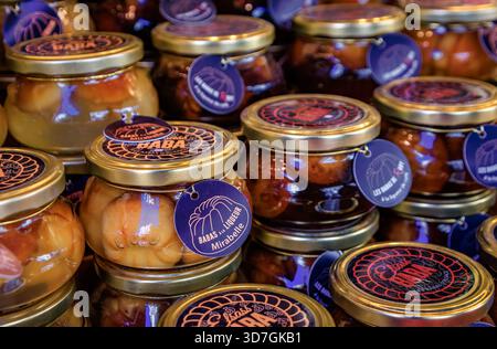 Colmar, Frankreich - 14. Dezember 2024: Gläser Baba au Rhum oder Rum Baba Kuchen in Mirabellen-Pflaumenlikör getränkt, Weihnachtsmarkt Stockfoto