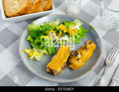 Gebratene Hähnchenstücke mit Gemüsesalat aus Mais und Salat Stockfoto