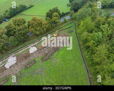 Luftaufnahme einer Baustelle mit Bagger in einer grünen Feldlandschaft, Bau PV Freifaechenanlage, weil der Stadt, Deutschland Stockfoto