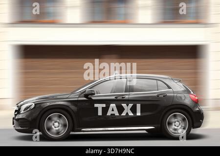 Taxiwagen mit Top-Schild und Logo fahren auf der Stadtstraße. Bewegungsunschärfeeffekt Stockfoto