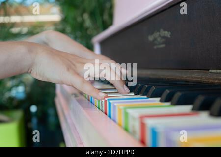 Eine Person spielt Klavier mit Regenbogenfarben und spielt eine wunderschöne Melodie. Hamilton, ON Stockfoto